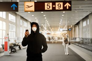 Men with respirator mask in airport. Covid-19 and Air pollution concept.